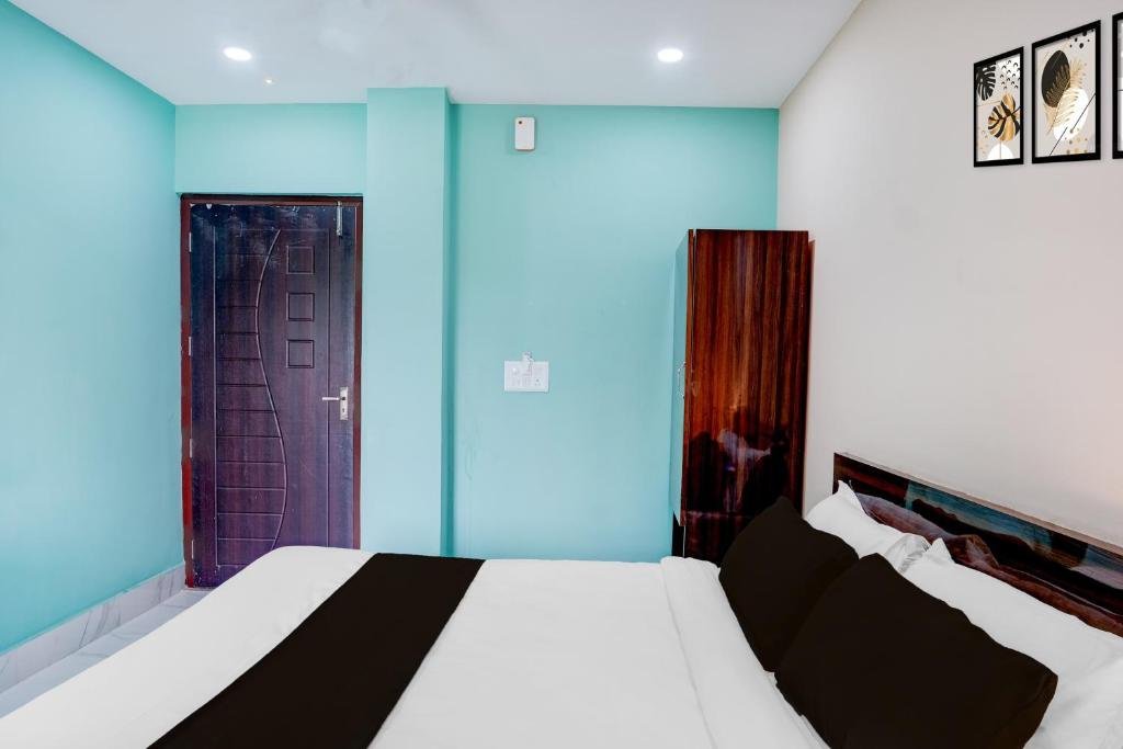 a bedroom with a bed and a purple door at Hotel O The Pride Inn Basistha Road in Khānāpāra