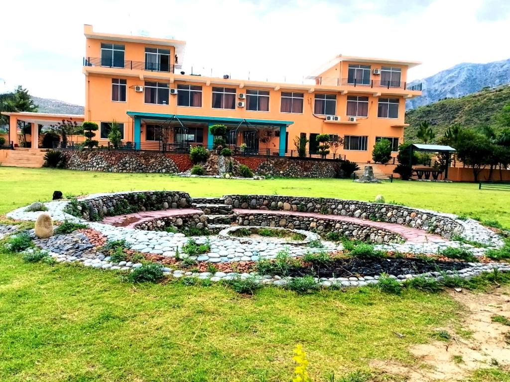 a building with a garden in front of a building at Sunset Creek in Harīpur