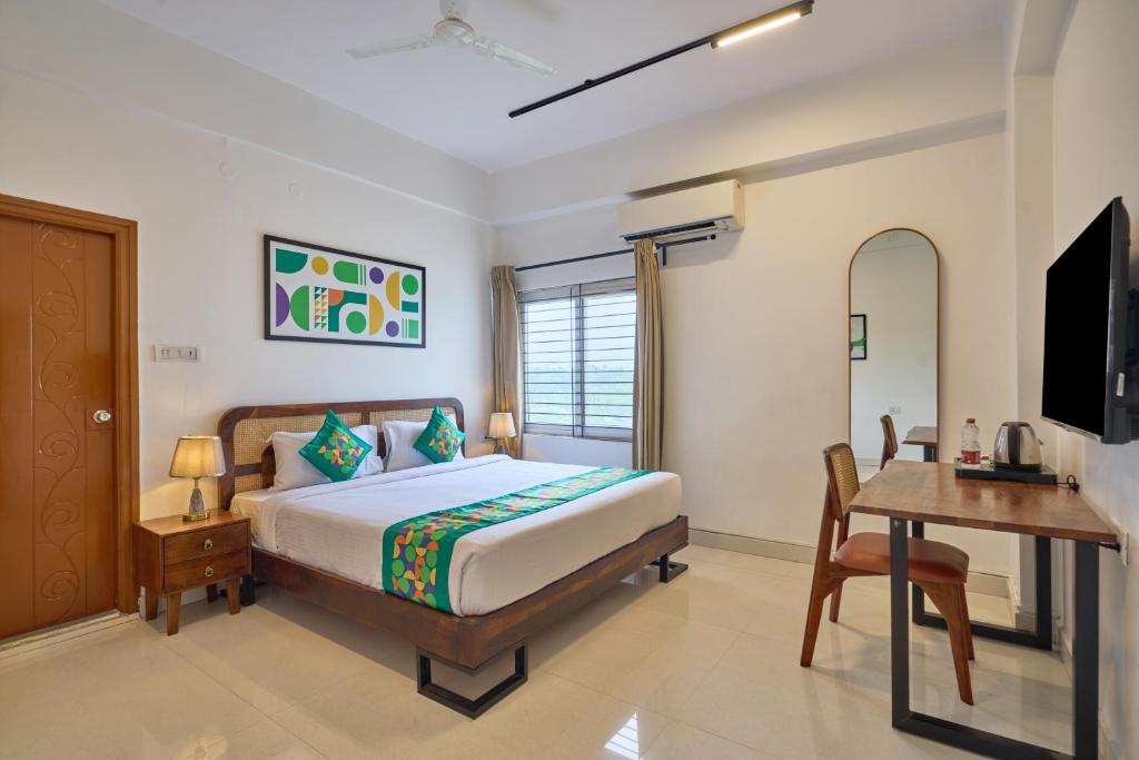 a bedroom with a bed and a desk and a television at Treebo Cultura in Hyderabad