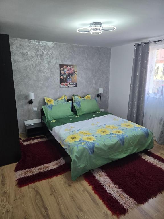 a bedroom with a large bed with green sheets and pillows at Casa Valor in Lacu Rosu