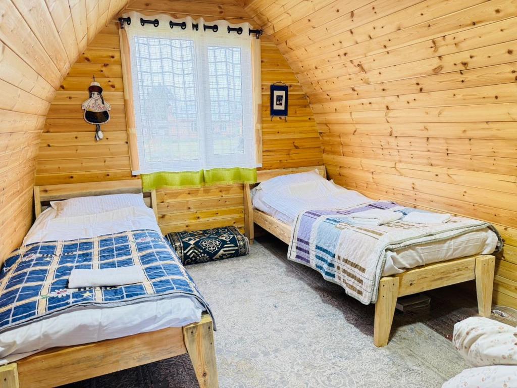 a bedroom with two beds in a log cabin at Aalam ordo in Shabdan
