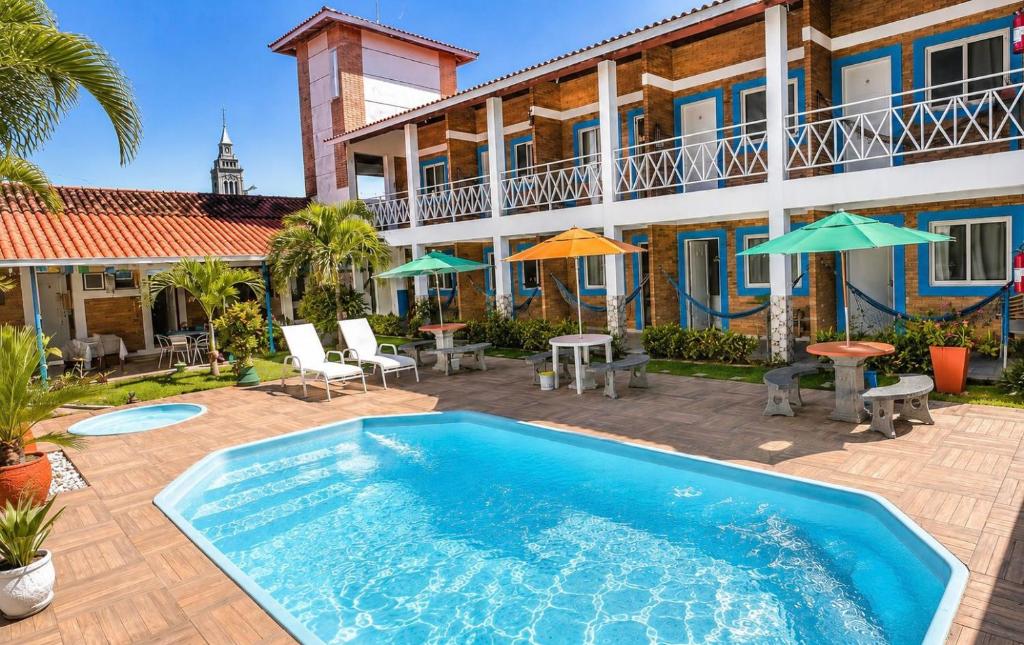 a swimming pool in front of a house at Torre do Sol in Praia do Frances