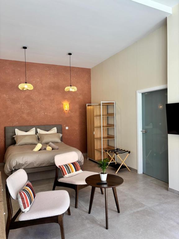 a bedroom with a bed and a table and chairs at Le Studio Côté Cour in Oberbetschdorf