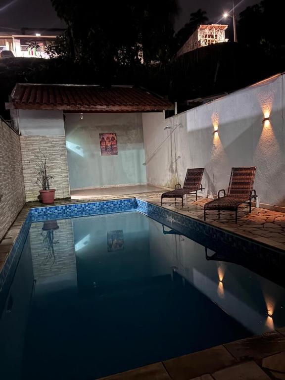 a swimming pool at night with two chairs in it at Casa dos bons encontros in Santa Isabel