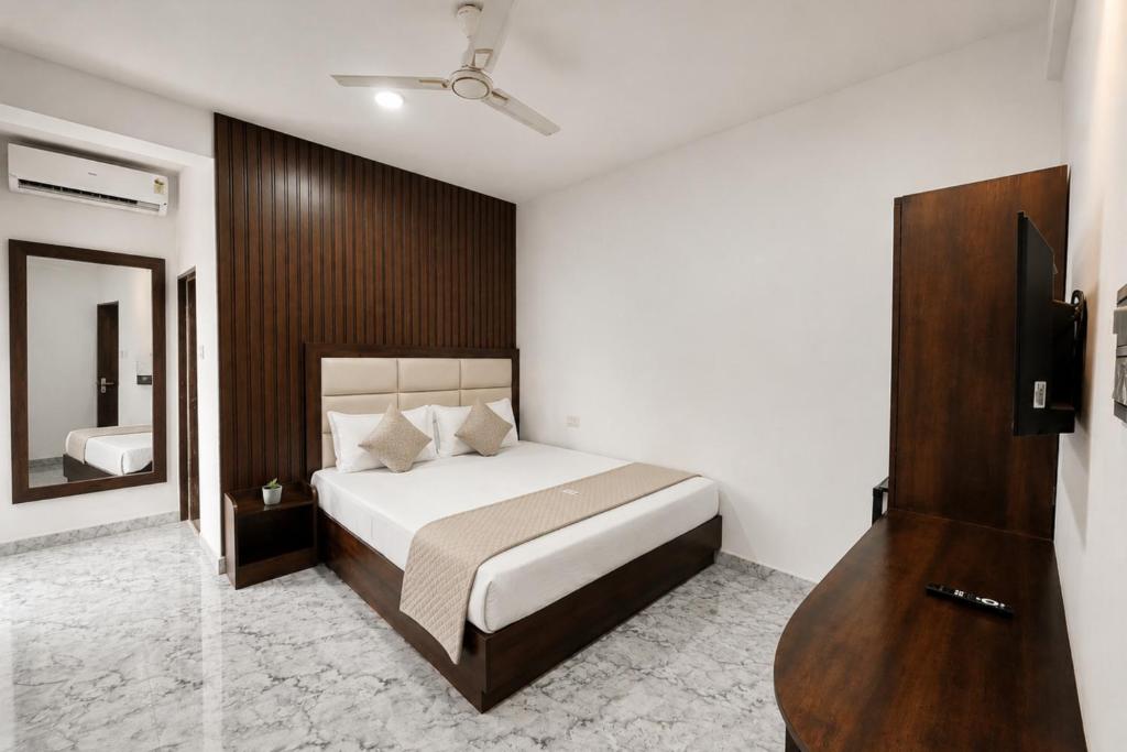 a bedroom with a large bed and a mirror at Hotel Not Dot in north GOA in Calangute