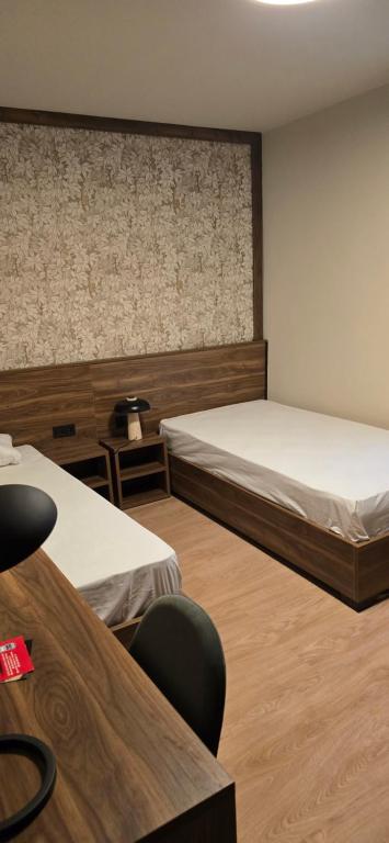 a room with two beds and a table and chairs at Drei Schweizer Hotel 201 in Neuwied