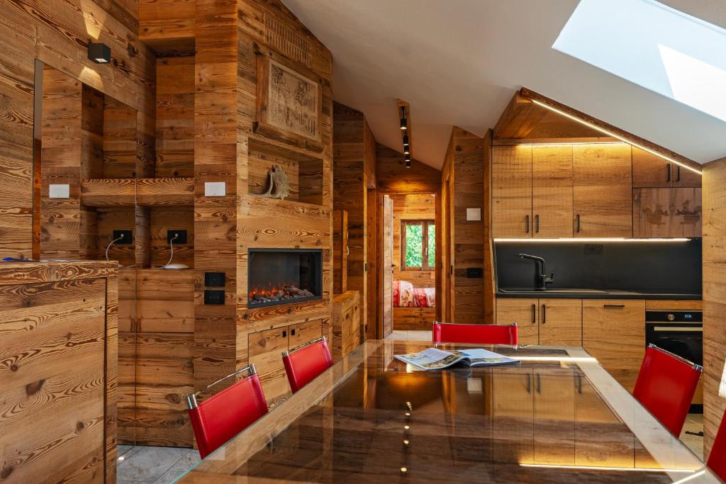 a dining room with a glass table and red chairs at Bertuzzi Homes in Aprica