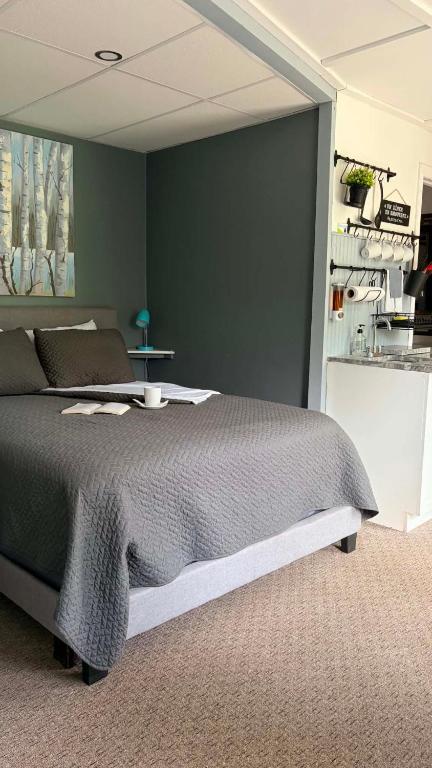 a bedroom with a bed and a green wall at La Spacieuse Riverstone CITQ3O1849 in Saint Pierre de Broughton