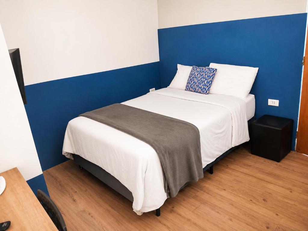 a bed in a room with a blue and white at Studiohaus Pertence in São Paulo