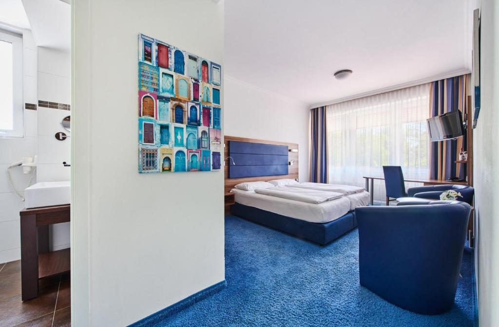 a hotel room with a bed and a blue carpet at Hotel am Gröbenbach in Gröbenzell
