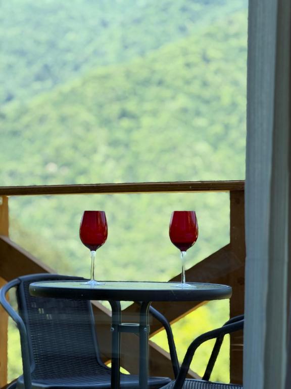 two glasses of red wine sitting on a table at Guri's hut in Kirnat'i