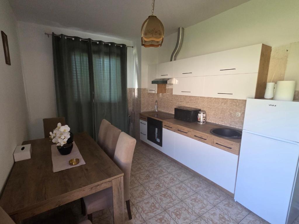 a kitchen with a table and a white refrigerator at Apartman Metković-stan na dan in Metković