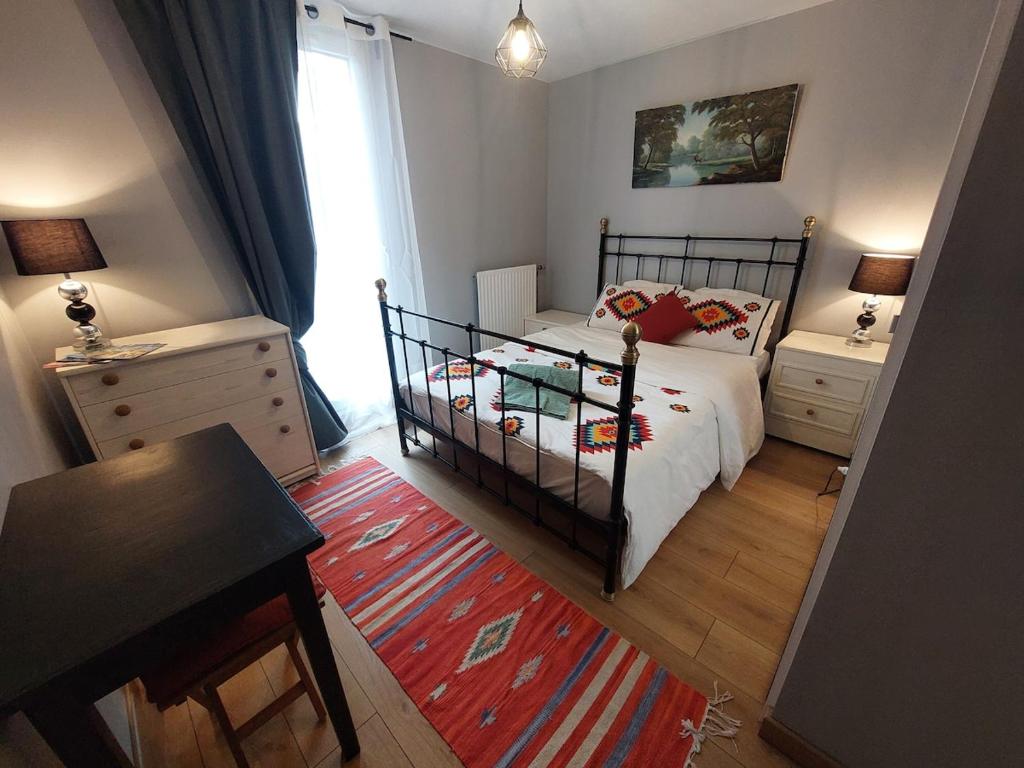 a bedroom with a bed and a table and a window at Chambre privée avec Jardin in Les Ulis