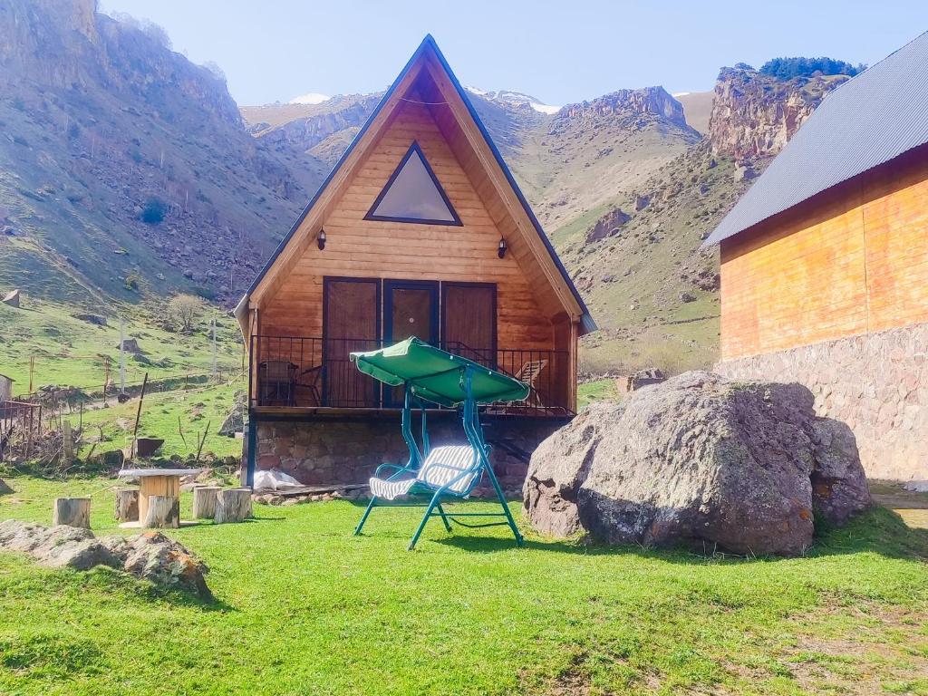 a house with a green structure next to a rock at Gold Star in Kazbegi