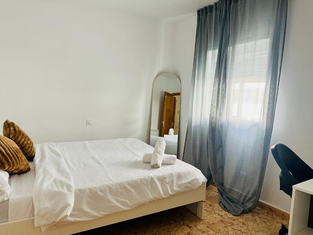 a bedroom with a white bed and a mirror at Fórmula 1 aeropuerto in Madrid