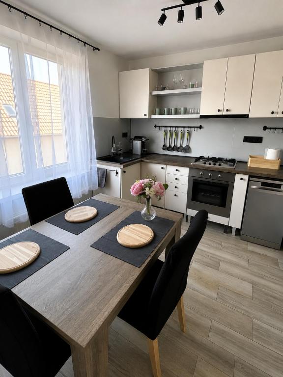 a kitchen with a wooden table and a dining room at By the Center in Balatonalmádi
