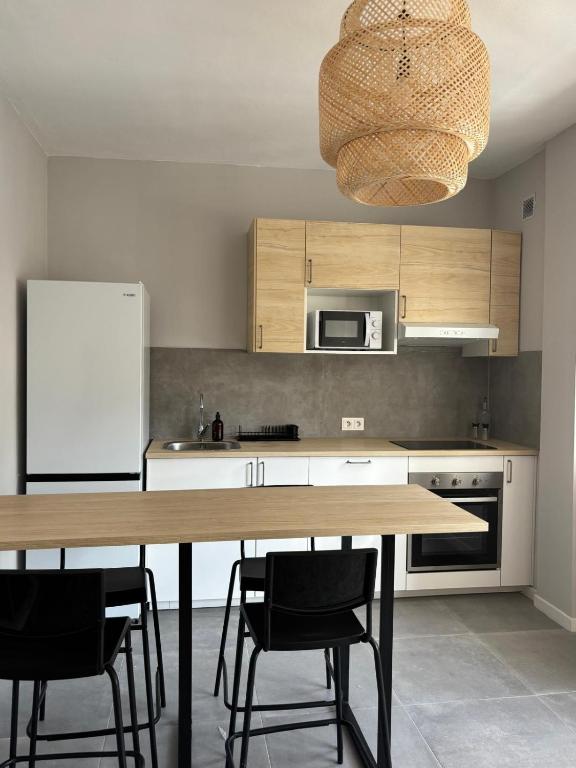 a kitchen with a table and chairs and a refrigerator at El Volcan in Los Llanillos