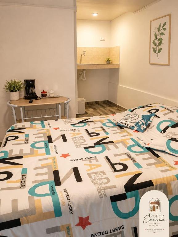 a bed in a room with a comforter on it at Donde Emma in Salamina