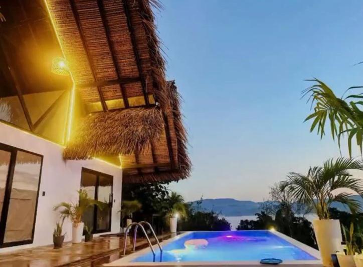 a swimming pool in front of a house at Majaz Cabaña Premium Paucar in Sauce