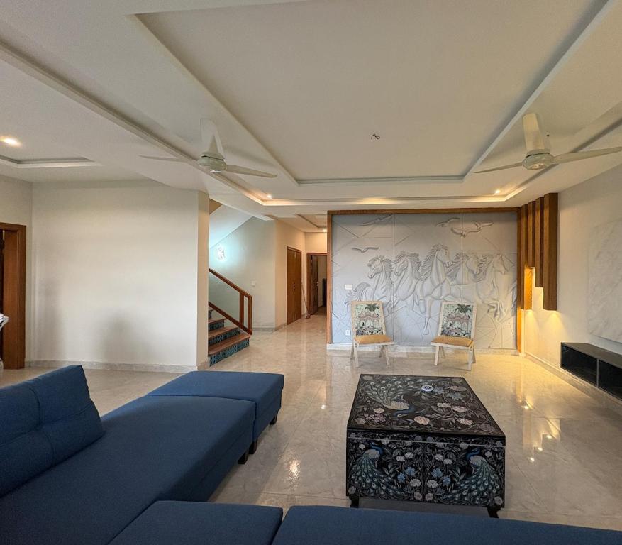 a living room with a blue couch and a table at The Elysian Villa in Murree