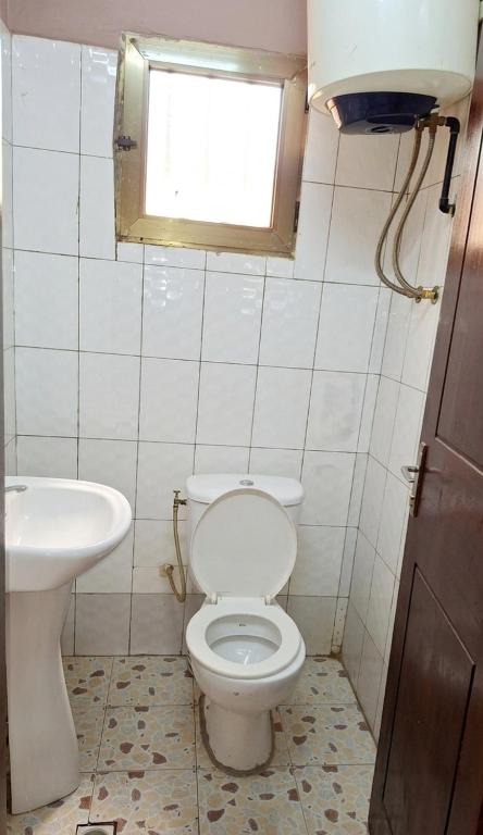 a bathroom with a toilet and a sink at BKSF Wemtenga 1 in Ouagadougou