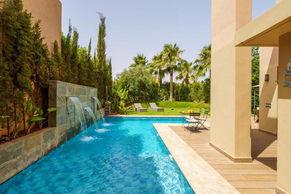 a swimming pool in a yard with a house at Prestigia Golf Marrakech Villa de Luxe avec Piscine Privée 3 Suites in Marrakesh