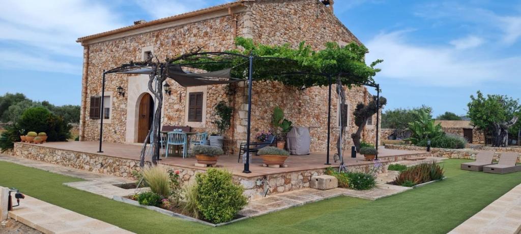 a stone building with a patio in a yard at Son Garrot in Santanyi