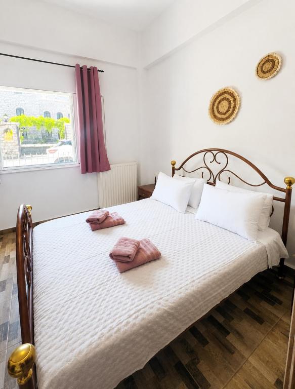 a bedroom with a bed with two pink towels on it at Mani Spot Manani in Pyrgos Dirou
