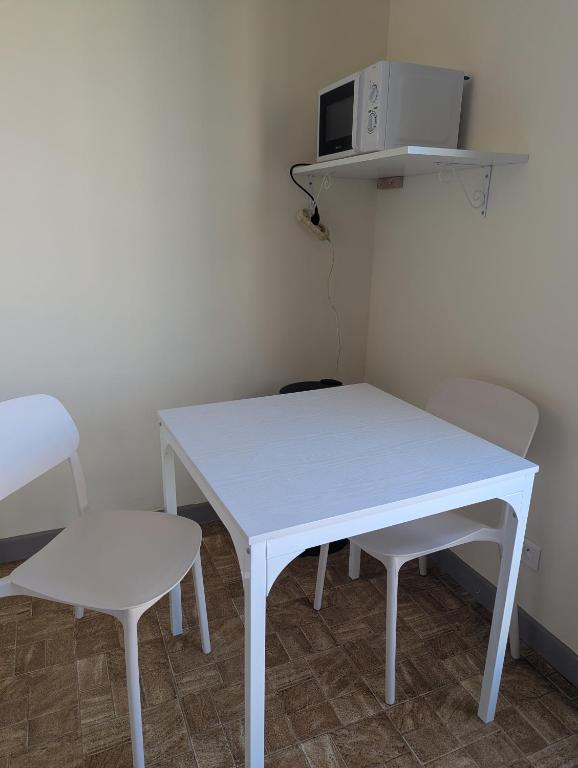 a white table and two chairs in a room at Studio Issoire pour 2 adultes et 1 enfant in Issoire