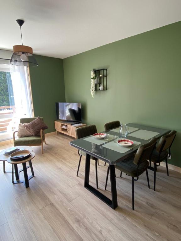 a living room with a table and chairs and a couch at Appartement Plein Soleil in Les Rousses