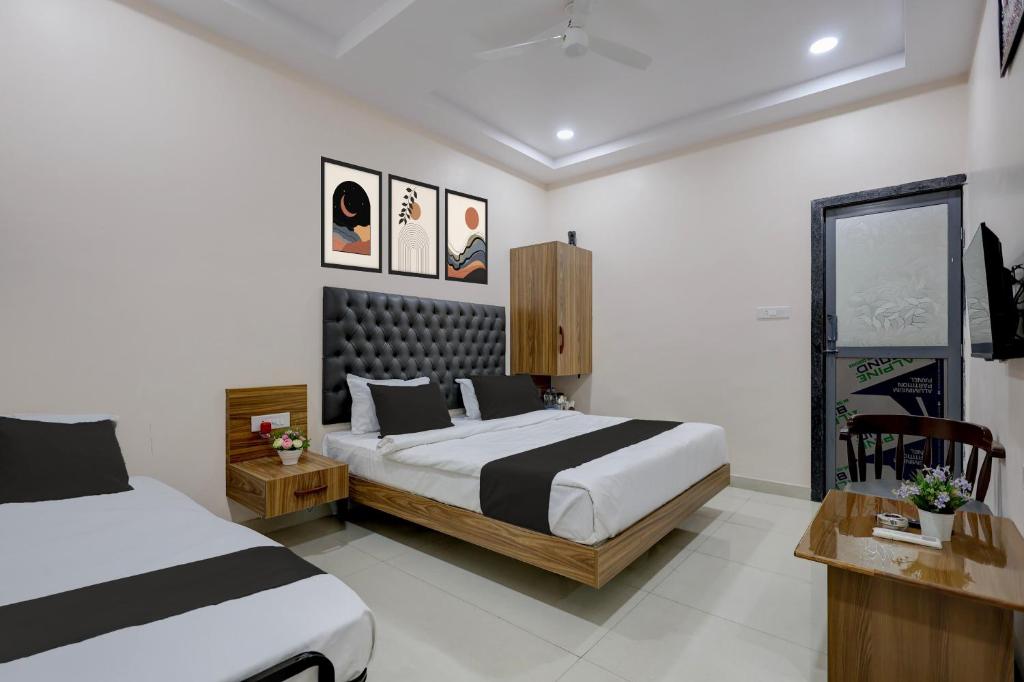 a bedroom with two beds and a desk and sidx sidx sidx at Super HOTEL O MATRI CROWN in Raipur