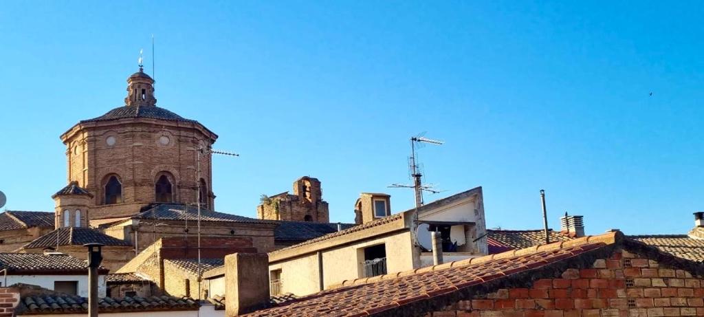an old building with a clock tower and roofs at Ca Muns Pares in Ginestar