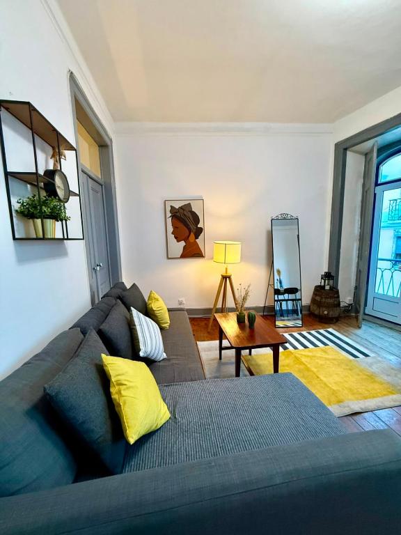 a living room with a couch and a table at Spacious T4 Central Apartment with Iconic Tram 28 View in Lisbon