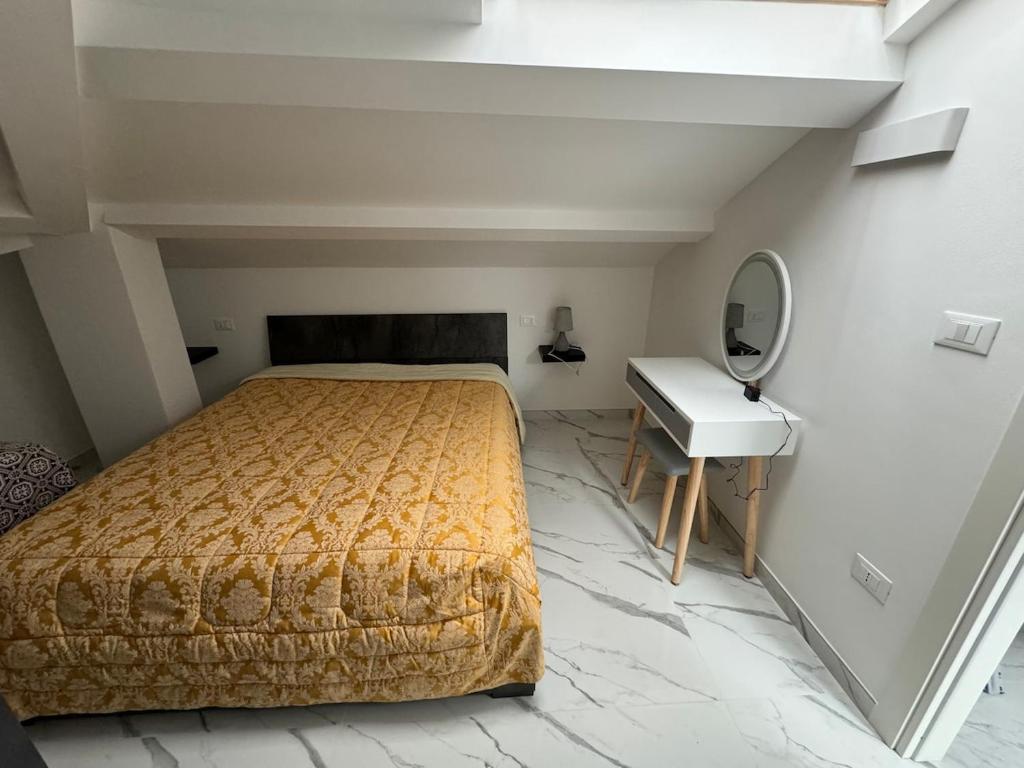 a bedroom with a bed and a desk and a sink at Mansarda al mare in Tortoreto Lido