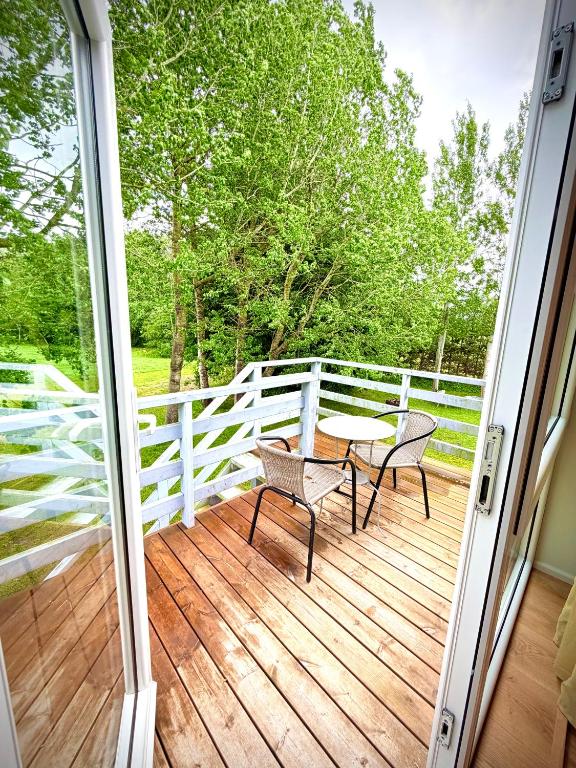 a balcony with a table and chairs on a deck at Lejnieki Apartment 4 in Pape