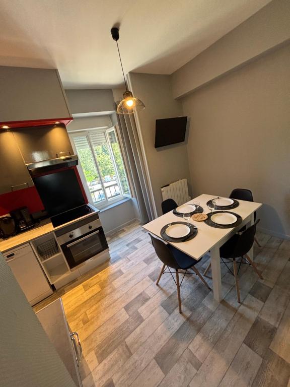 a kitchen and dining room with a table and chairs at Le repos des sommets in La Bourboule