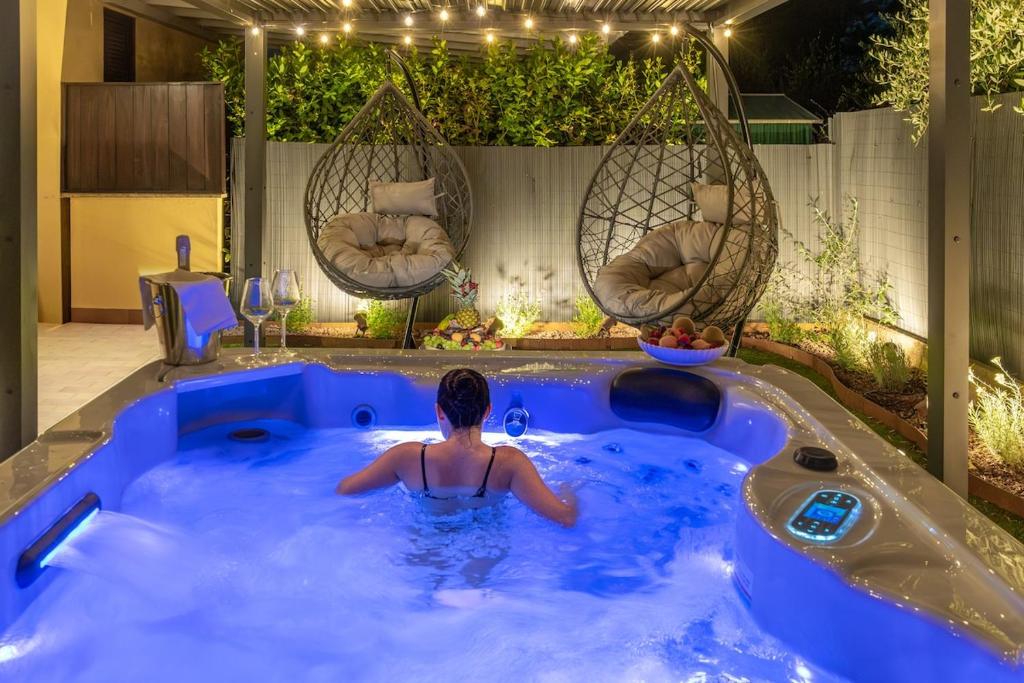 a man in a hot tub in a backyard at Luxury Garden Suite with Private Heated jacuzzi in Perugia