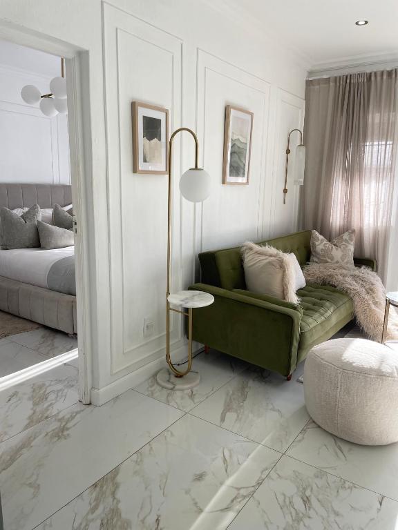 a living room with a green couch and a bed at Privately Owned Apartment at Ocean View Villas in Port Edward