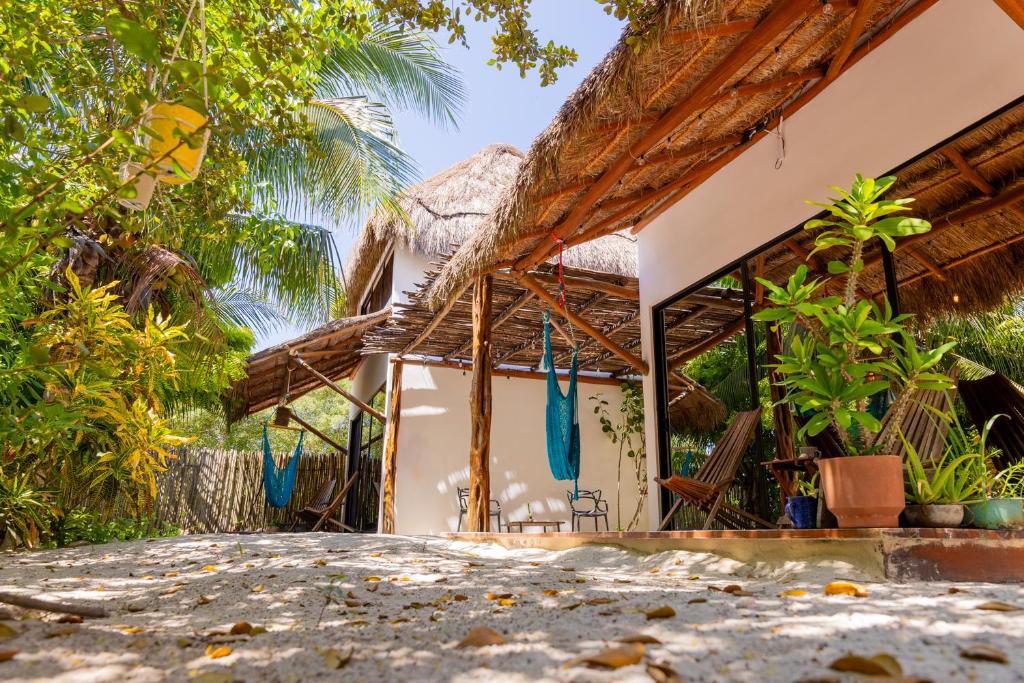 a house with a thatched roof and a patio at Ca Nikte Cabañas in El Cuyo