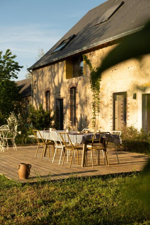 a group of chairs and tables on a wooden deck at Maison d'hôtes le détour en pleine nature in Channay-sur-Lathan