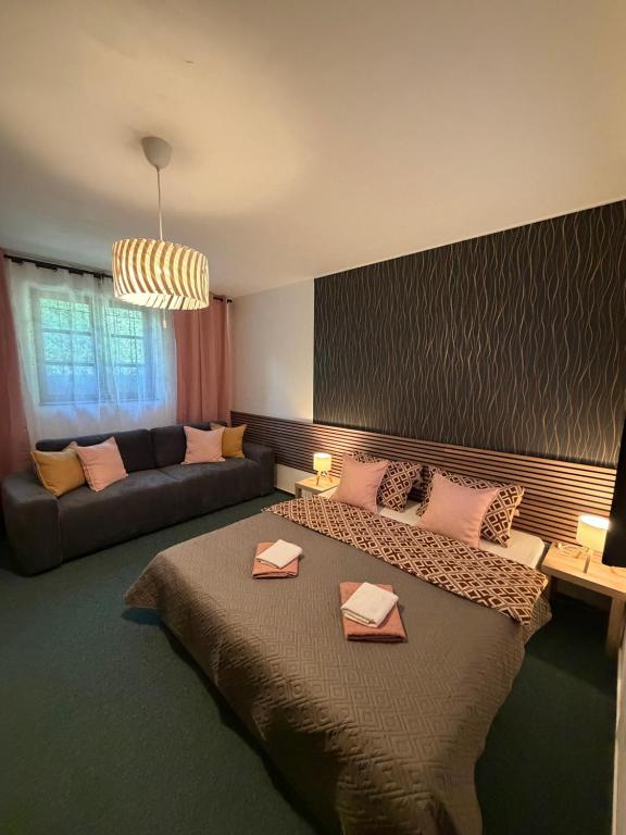 a bedroom with a large bed and a couch at Penzion Amfik in Mikulov
