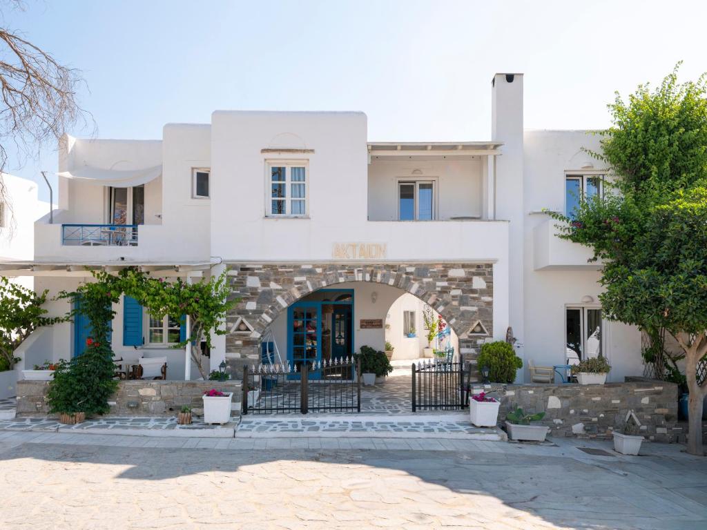 a white building with an archway in front of it at Akteon Hotel in Logaras