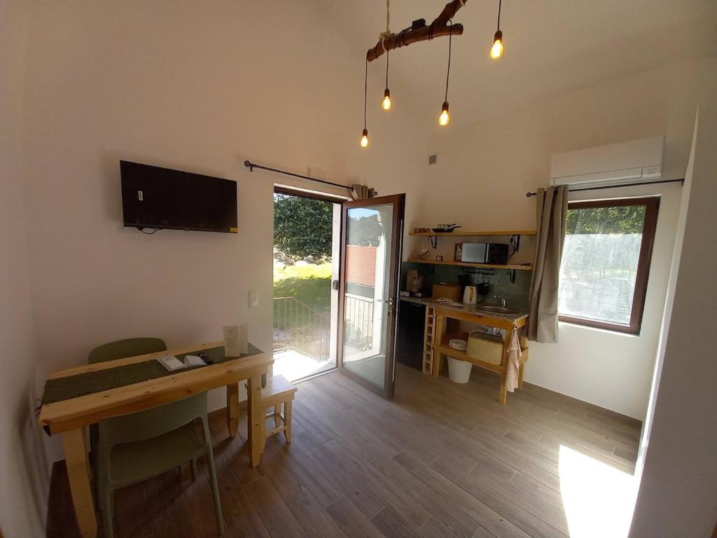 a living room with a dining table and a television at Quinta Pedra do Rio - Penedo in Salvador do Monte