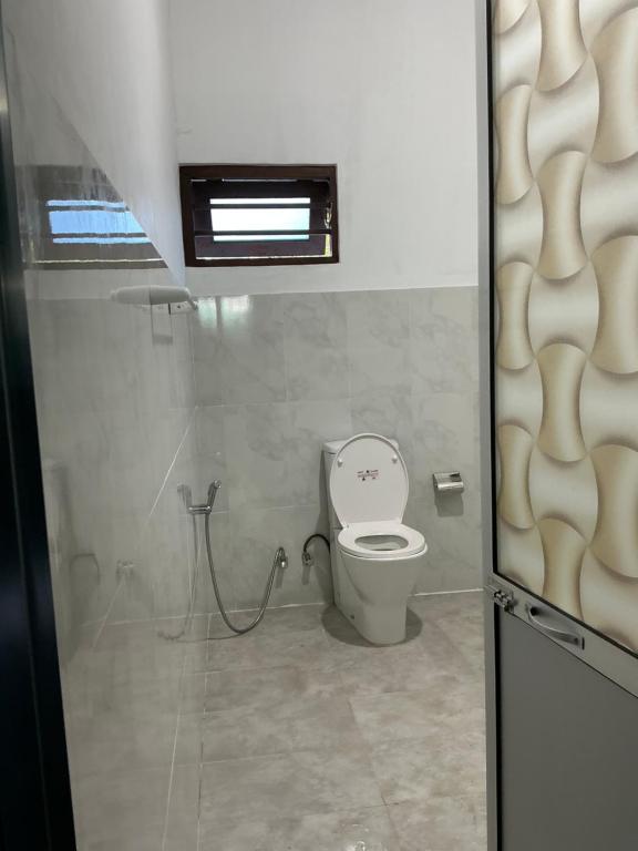 a bathroom with a toilet in a room at Villa Sadalla in Hikkaduwa