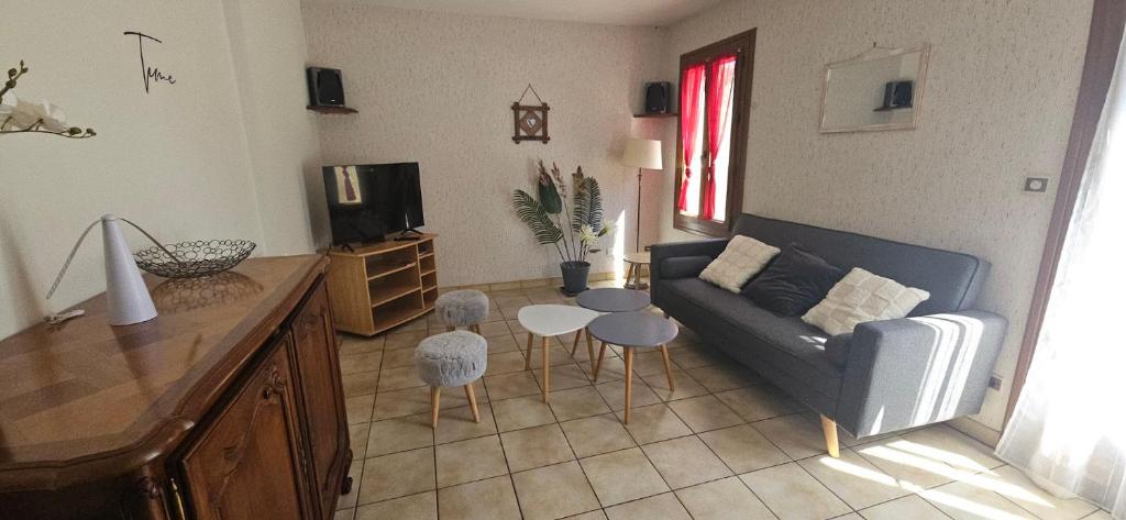 a living room with a couch and a table and chairs at Le logis de l'Ajolaise in Vielle-Aure