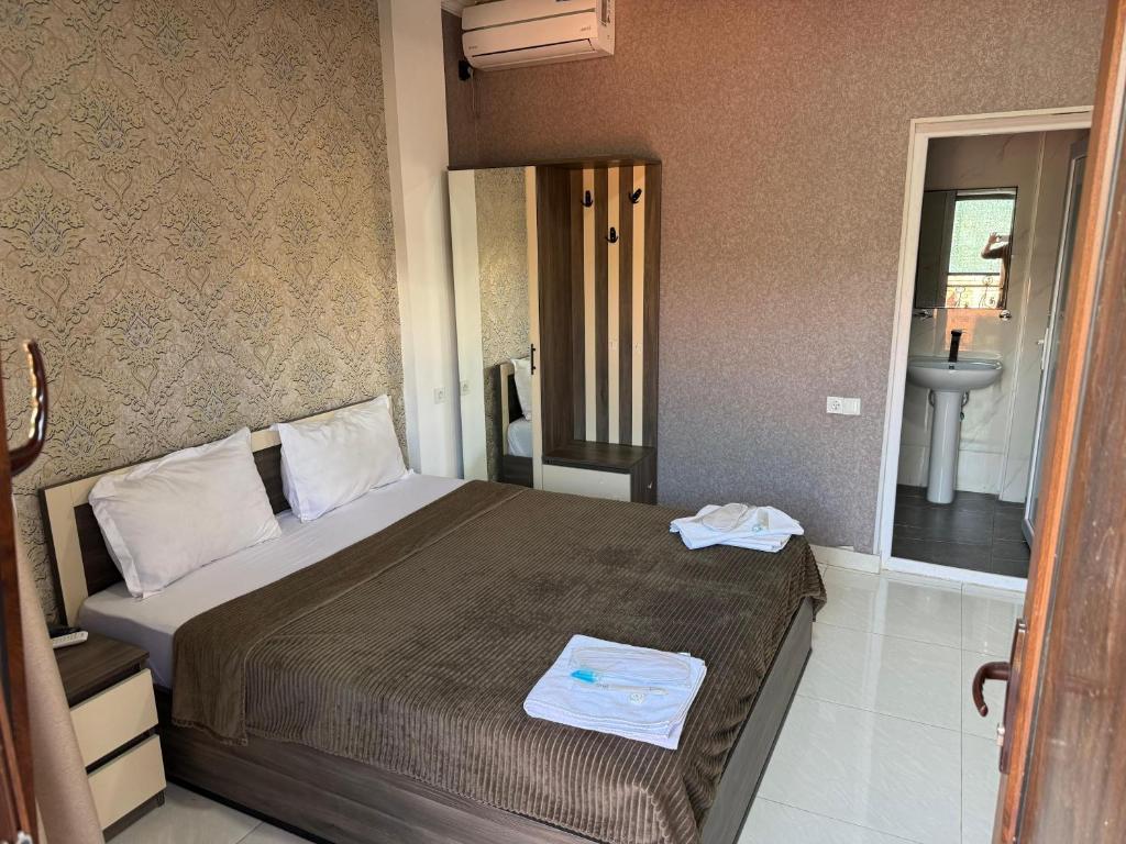 a bedroom with a large bed and a sink at Lux hotel in Tbilisi City
