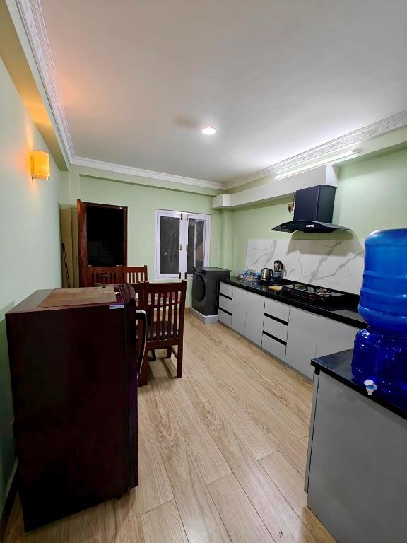 a kitchen with green walls and a wooden floor at Lalitpur stay in Pātan