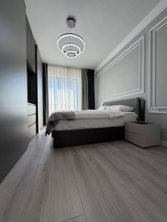 a bedroom with a bed and a large window at Best Luxury Residence in Bistriţa