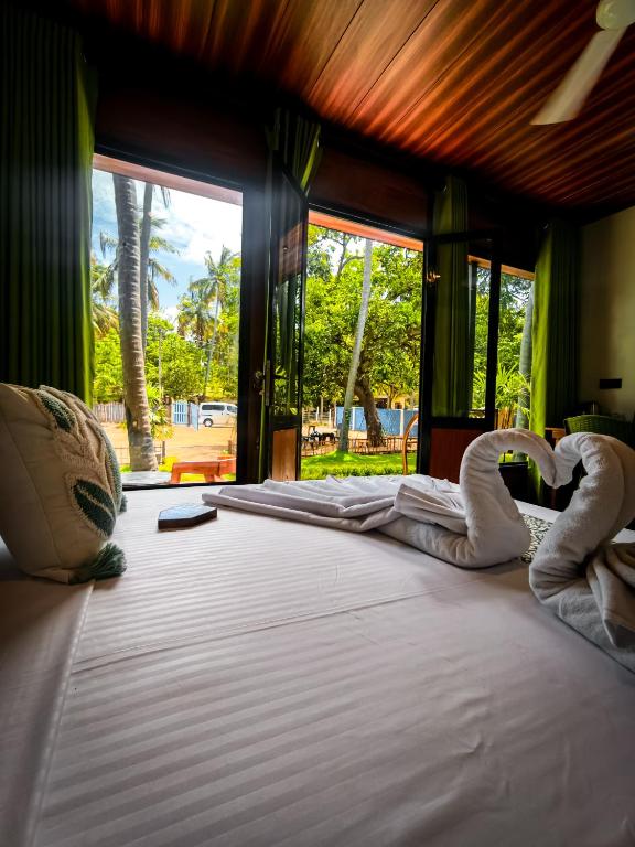 a bedroom with two swans laying on a bed at Rhythm Beach in Trincomalee