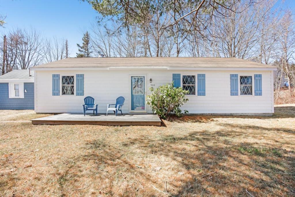 a white house with two chairs on a porch at Dog-friendly home in great locale close to the ocean with yard, streaming, W/D in Tremont